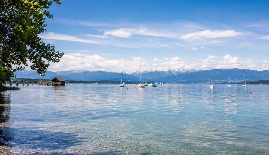 Starnberger See mit Segelbooten und Blick in die Landschaft